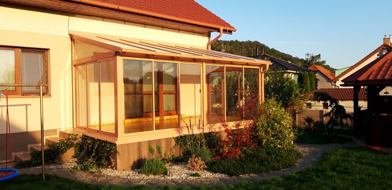 Hlinková zimna záhrada s bezpečnostným sklom na streche, bezpečnostným sklom ako výplň rámových posuvov a drevenou podlahou.