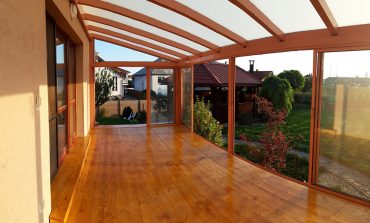 Hlinková zimna záhrada s bezpečnostným sklom na streche, bezpečnostným sklom ako výplň rámových posuvov a drevenou podlahou.