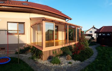 Hlinková zimna záhrada s bezpečnostným sklom na streche, bezpečnostným sklom ako výplň rámových posuvov a drevenou podlahou.